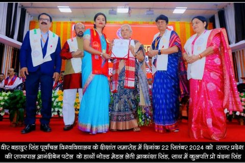 A graduate receiving a gold medal at the university convocation, with academic staff alongside