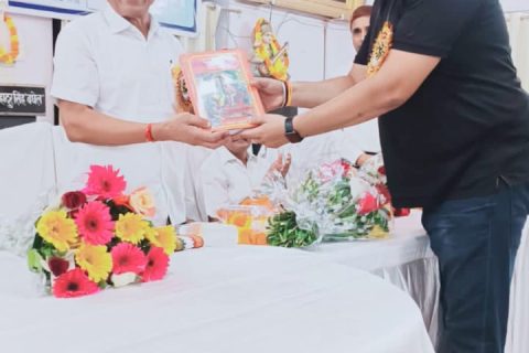 Two members of faculty exchanging a commemorative volume at the departmental seminar